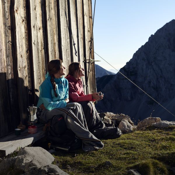 2 femmes assises près d’un refuge de montagne