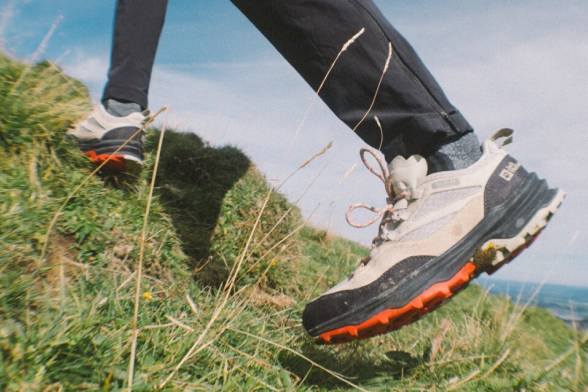 Sommerliche Aufnahme von zwei Wanderern mit Wanderrucksäcken im sportlichen Look von hinten